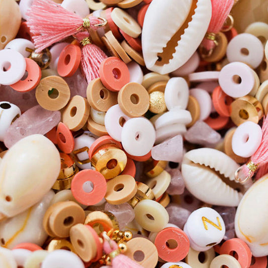 Mélange de perles colorées, lettres, coquillages activité anniversaire