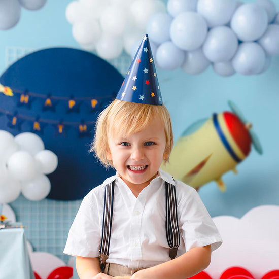 Enfant portant un chapeau de fête bleu marine à étoiles multicolores