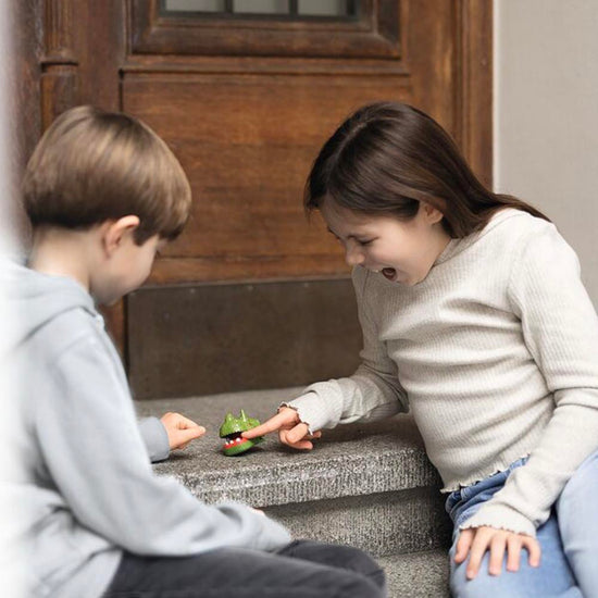 1 dino mordeur de doigt à glisser dans une pochette d'anniversaire surprise