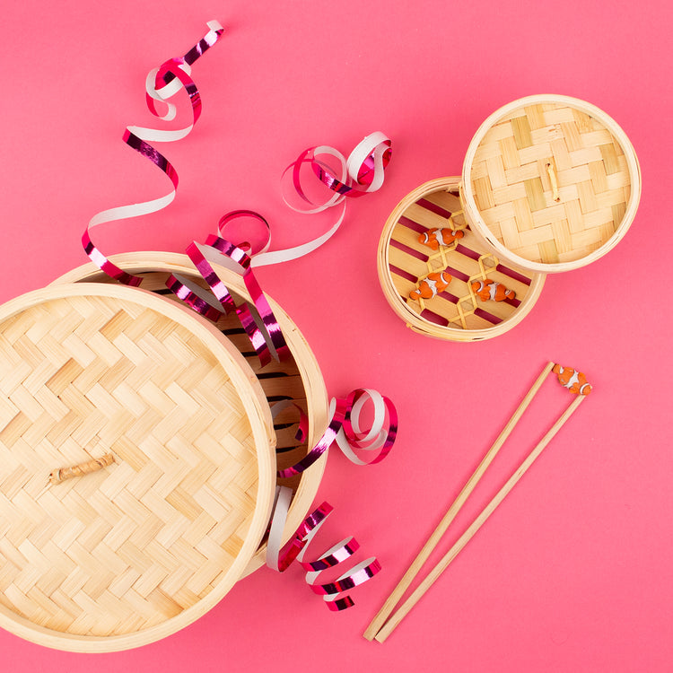 Table de fête ambiance Asie avec boîtes vapeur et serpentins roses