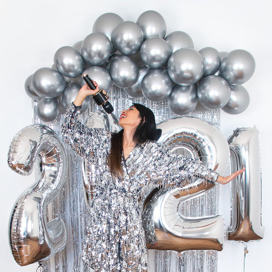 Decoración de Año Nuevo: arco de globos plateados con globos gigantes de números