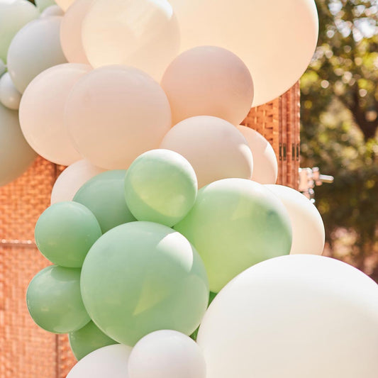 Dettaglio arco di palloncini a raggi di zenzero verde mandorla nudi e verdi per decorazioni nuziali