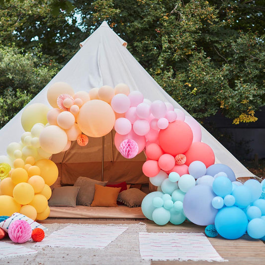 Giant rainbow balloon arch on teepee: birthday decoration by ginger ray