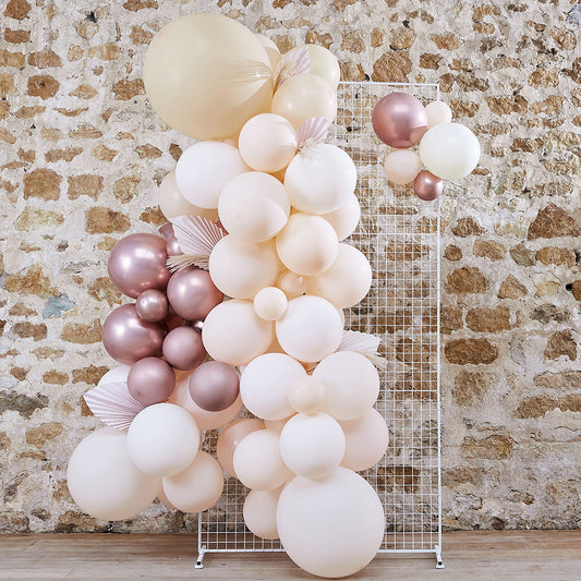 Arches of white champagne, rose gold and caramel colored balloons, wedding decoration fans, birthday