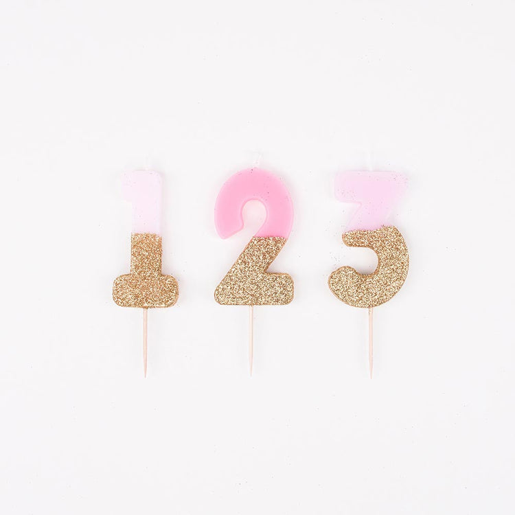 Velas con números rosas y doradas para decoración de tarta de cumpleaños de niña.