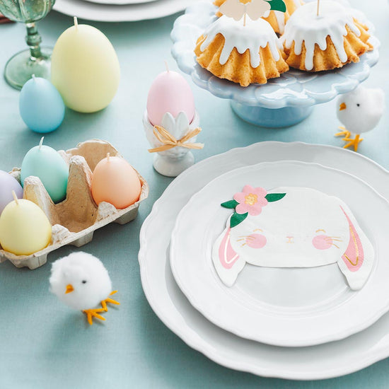 Table de paques avec bougies forme oeuf pastel et serviettes lapin