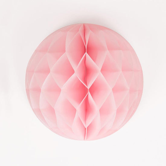 A pink honeycomb ball to hang for baby shower girl decoration