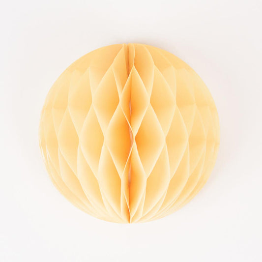 A yellow honeycomb ball for baby shower or birthday decoration