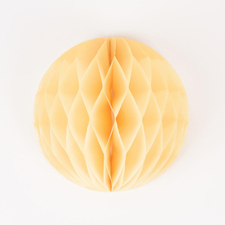 A yellow honeycomb ball for baby shower or birthday decoration