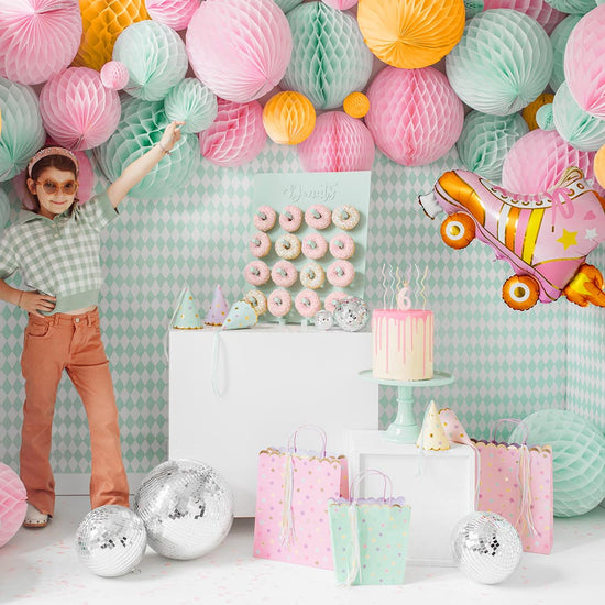 Décoration anniversaire pastel avec boules alvéolées et ballon roller