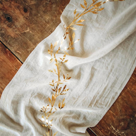 Camino de mesa color crema con patrón de follaje dorado: decoración de boda botánica