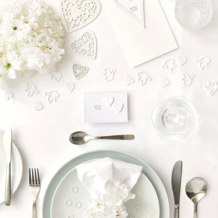 Fête avec un thème blanc : décoration de confettis coeurs bancs