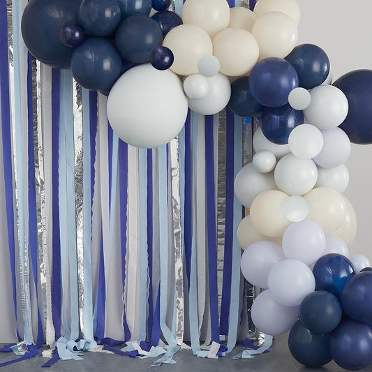 Decoración de pared con arco de globos y bandas de crepe azul y plata