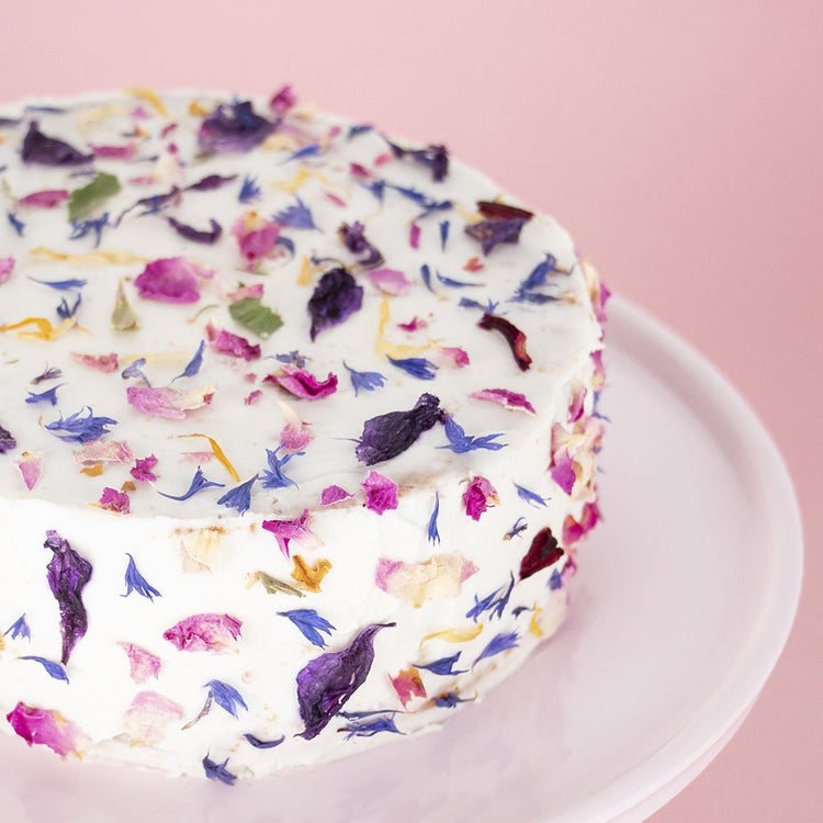 Un quatre-quart, du glaçage et des fleurs comestibles pour un gâteau féérique