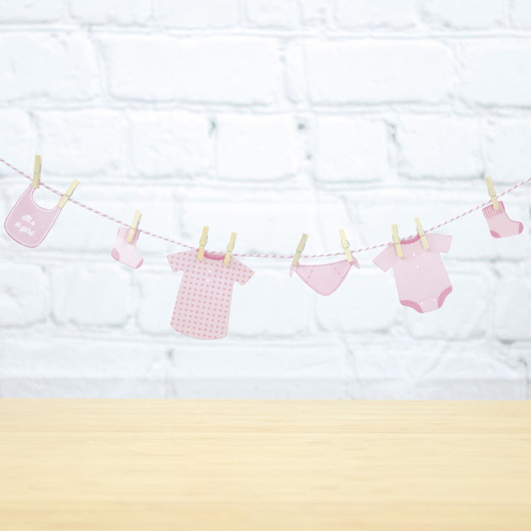 Guirlande avec vetements bébés roses pour deco gender reveal fille