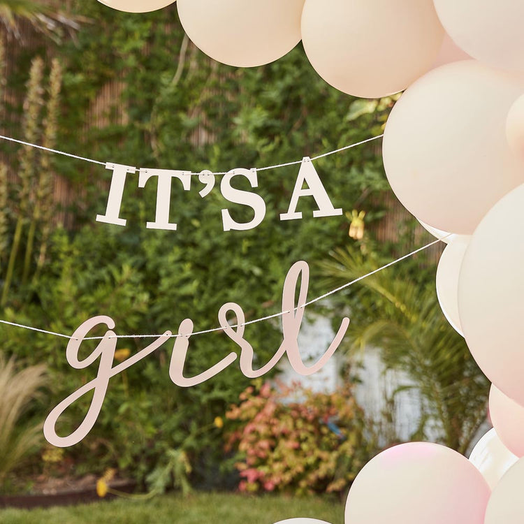 Arch of pink balloons and garland for decoration of gender reveal girl