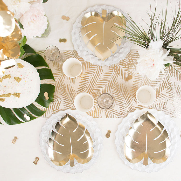 Détails table de mariage tropicale avec assiettes feuilles tropicales dorées