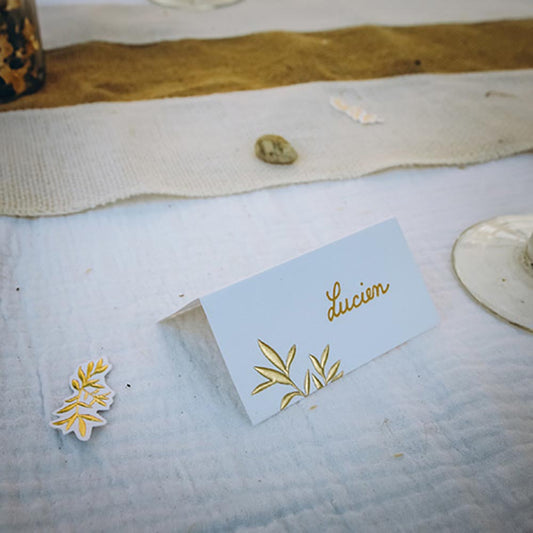 Decoración blanca y dorada para la mesa de la boda: tarjetas de lugar y confeti