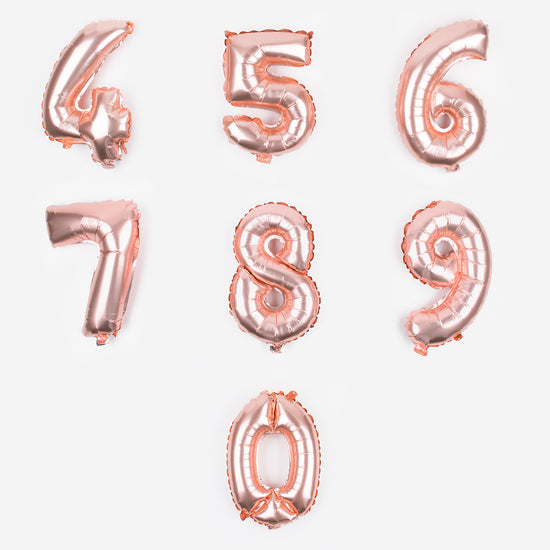 Pequeños globos de oro rosa con números del 4 al 9 para colgar en la decoración de una fiesta de cumpleaños.