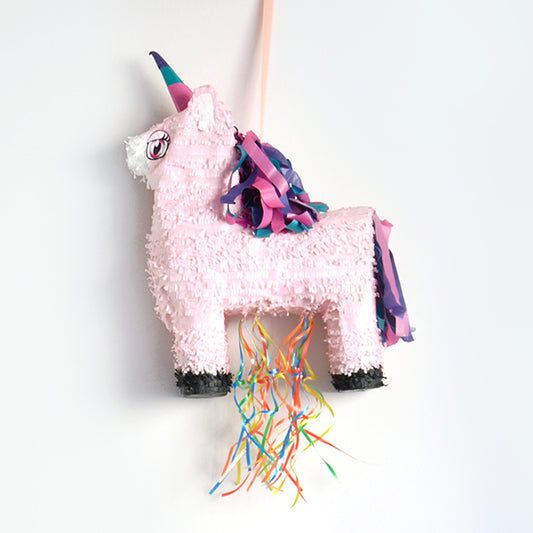 Una piñata con forma de unicornio para una fiesta de cumpleaños frenética con un tema de princesa hada