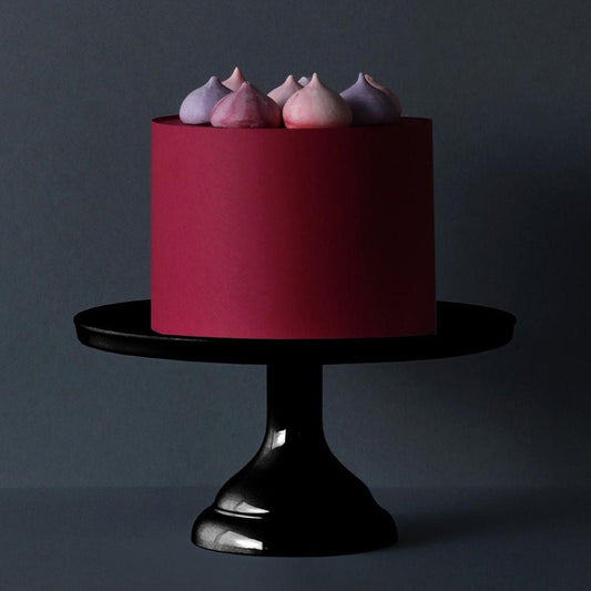 Elegante pastel de cumpleaños con un pequeño soporte para pasteles negro