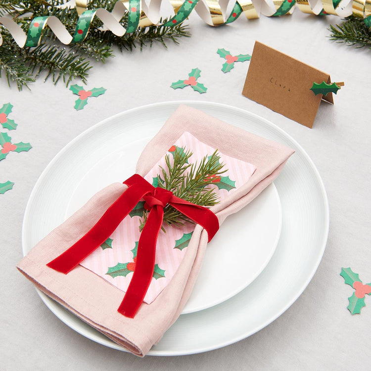 Mesa navideña tradicional con servilletas de acebo y confeti de acebo