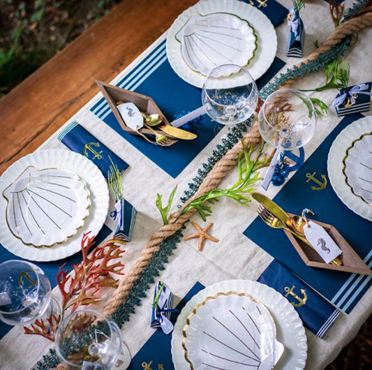 Idea decorativa para una mesa de boda marinera infantil: manteles individuales y decoración marinera