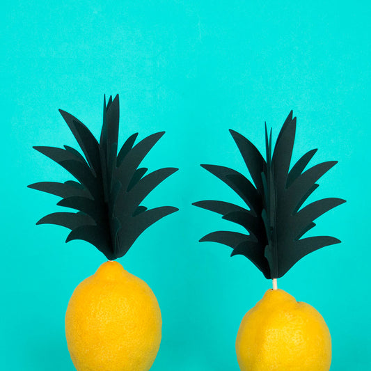 Idea de decoración tropical: palitos de piña plantados en limones