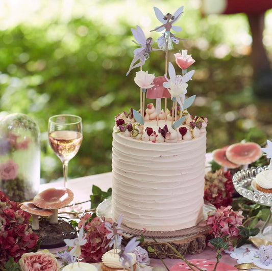 Pastel de cumpleaños de hadas con toppers de hadas Meri Meri y adornos florales